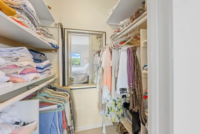 a bathroom with a toilet a sink a mirror a shower a vanity and window