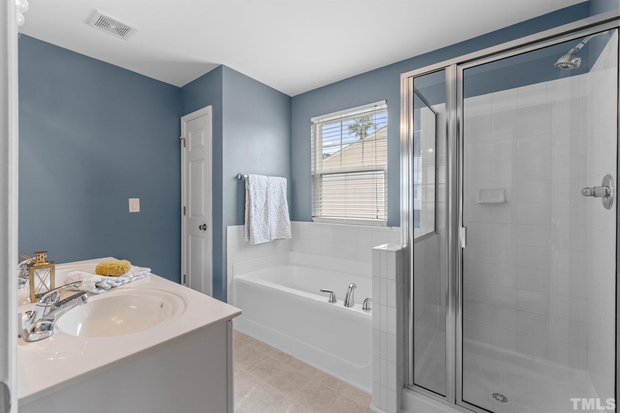 11720 Coppergate Drive, Unit 100 Raleigh, NC 27614 - Photo 13 of 22 a bathroom with a sink a shower and a mirror