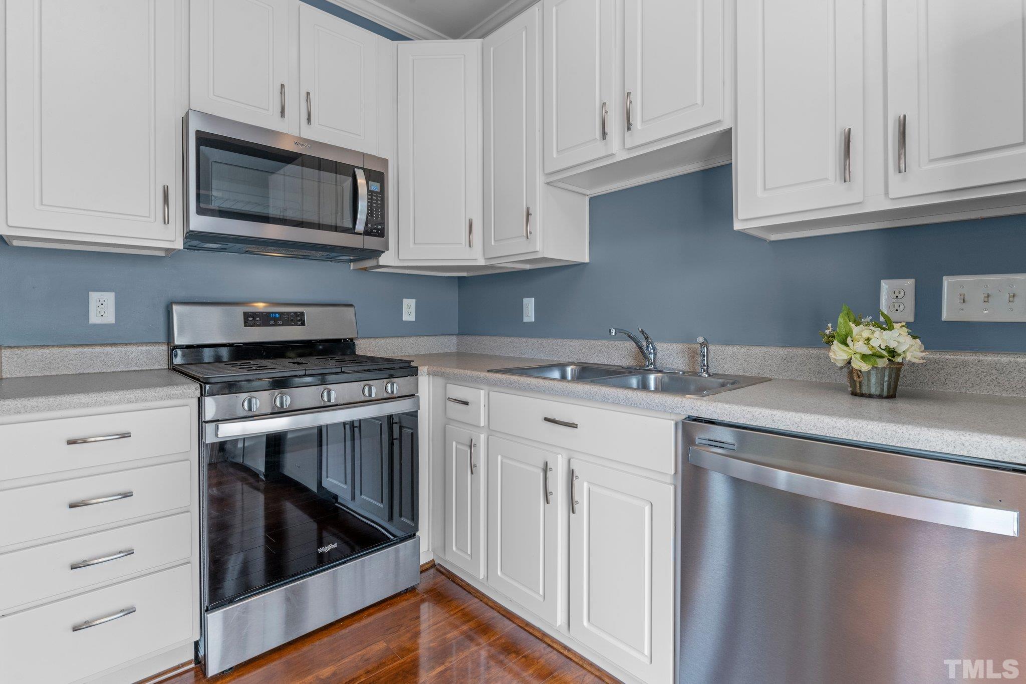 11720 Coppergate Drive, Unit 100 Raleigh, NC 27614 - Photo 7 of 22 a kitchen with stainless steel appliances granite countertop white cabinets a sink and dishwasher