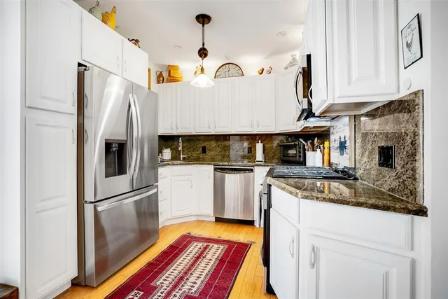 a bedroom with a bed a chandelier and a potted plant on the dresser