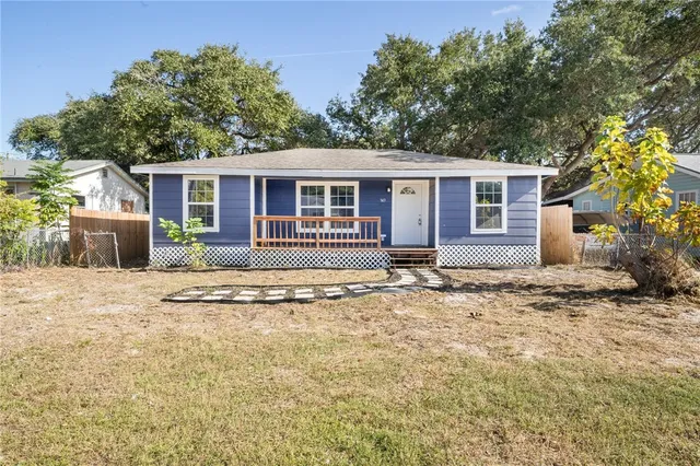 a front view of a house with a yard and potted plants