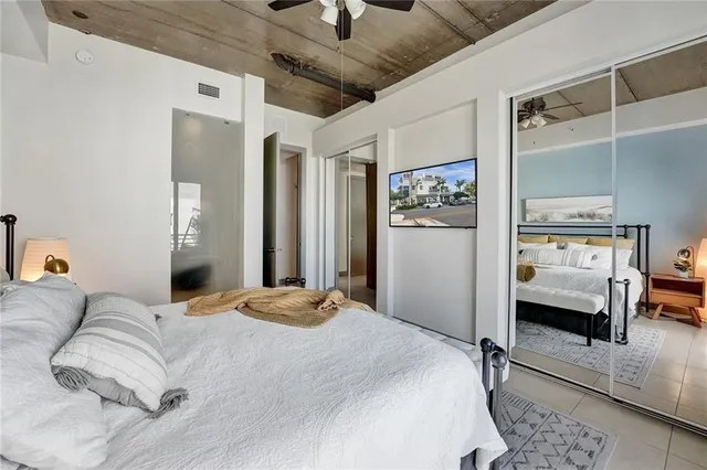 a bedroom with a large bed and a chandelier