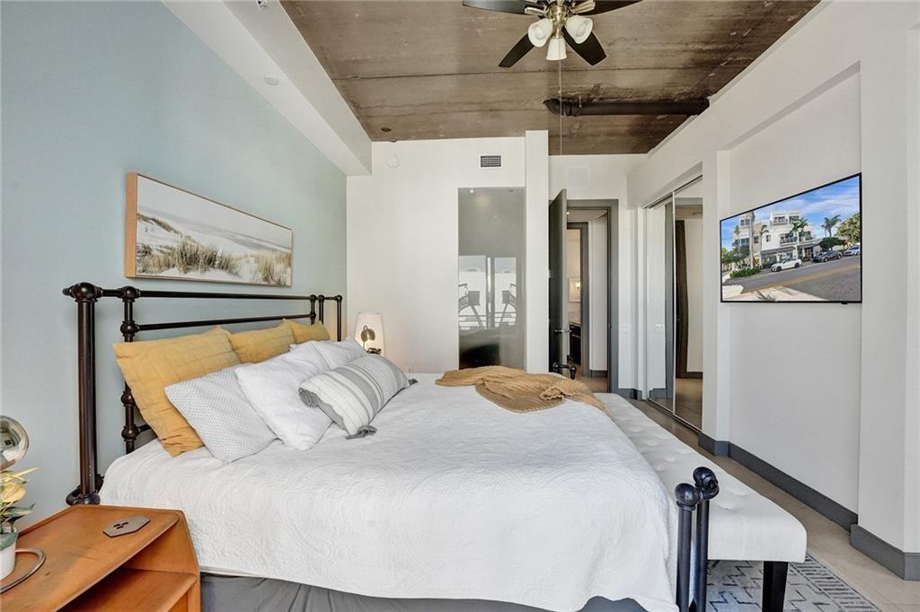 110 Southeast 2nd Street, Unit 402 Delray Beach, FL 33444 - Photo 24 of 49 a bedroom with a large bed and a chandelier