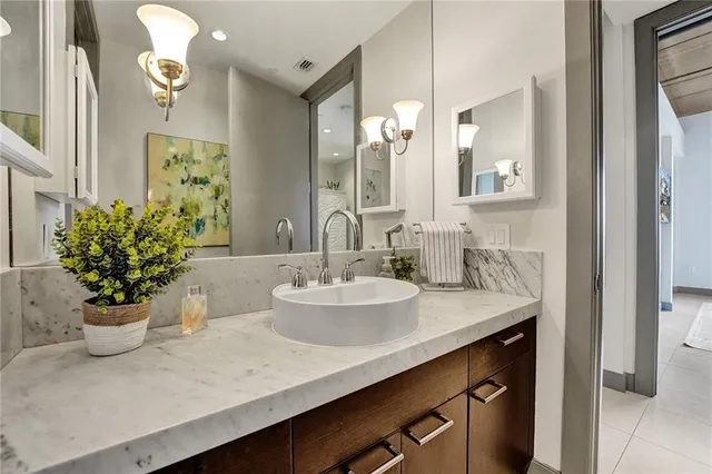a bathroom with a granite countertop sink a toilet and shower