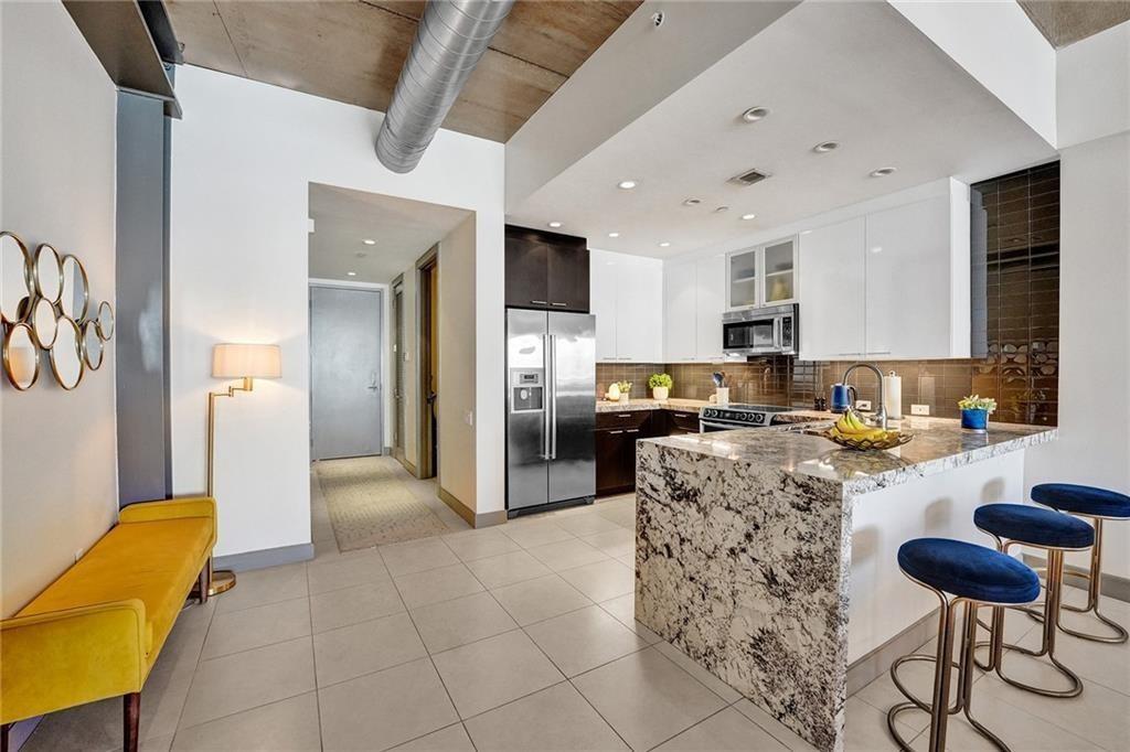 110 Southeast 2nd Street, Unit 402 Delray Beach, FL 33444 - Photo 3 of 49 a kitchen with stainless steel appliances granite countertop a refrigerator and a stove top oven