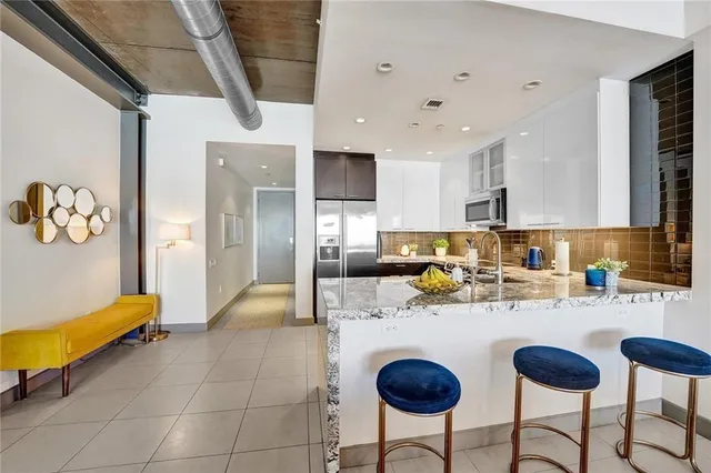 a kitchen with stainless steel appliances granite countertop a sink and a refrigerator