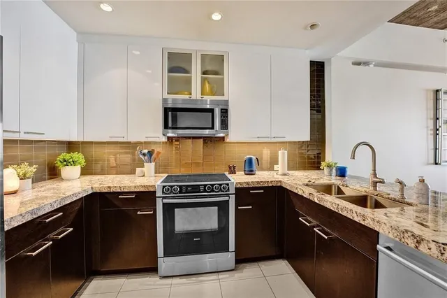 a kitchen with stainless steel appliances granite countertop a stove a sink dishwasher and a microwave