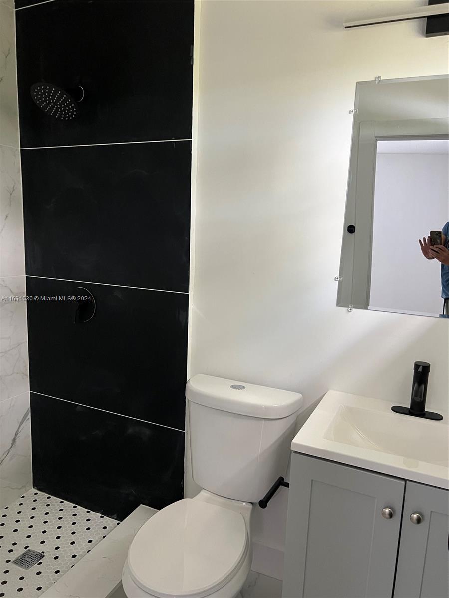 945 Curtiss Drive Opa-Locka, FL 33054 - Photo 11 of 18 a bathroom with a sink a toilet and a mirror