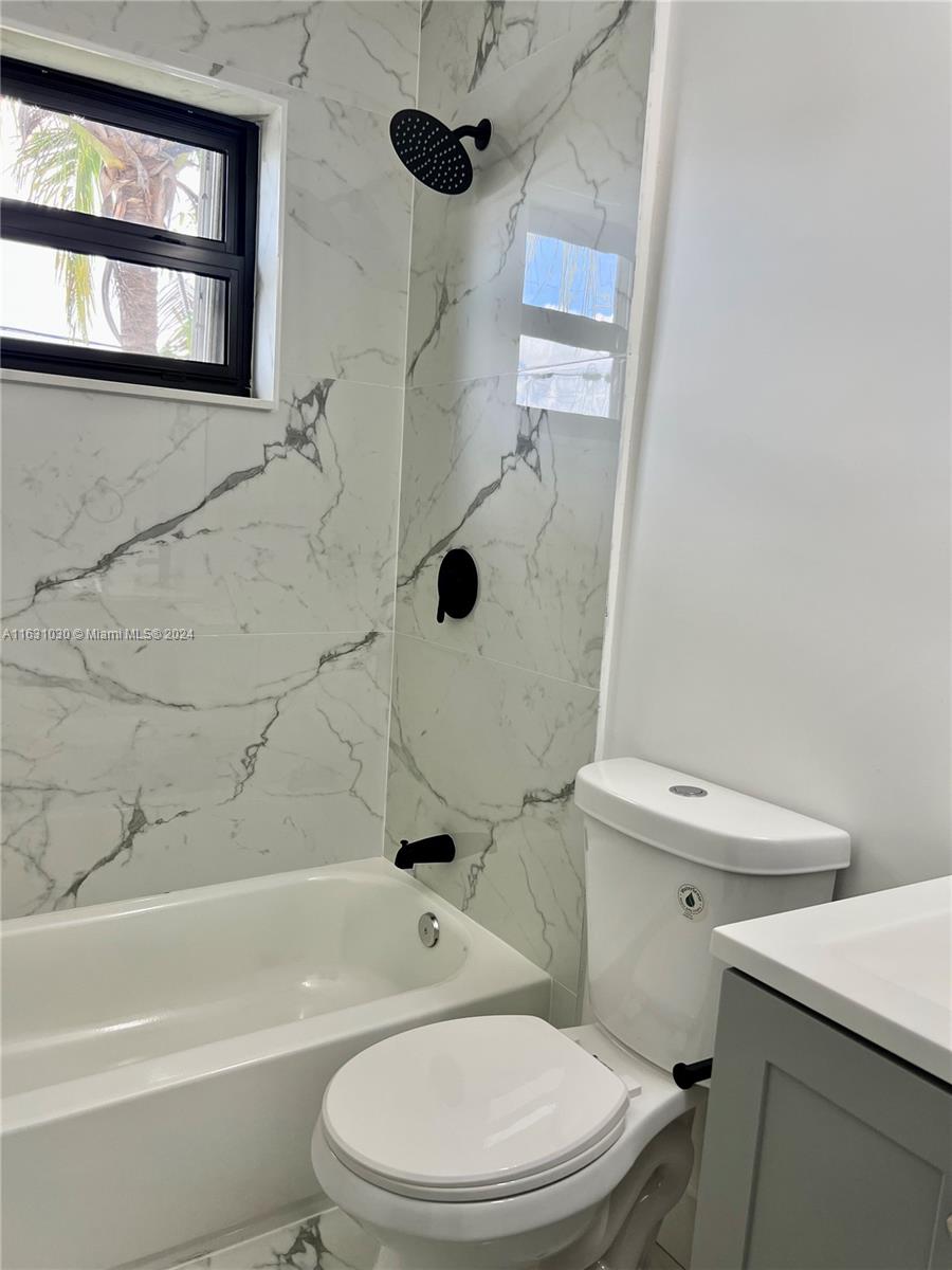 945 Curtiss Drive Opa-Locka, FL 33054 - Photo 17 of 18 a white toilet and tub sitting next to a window