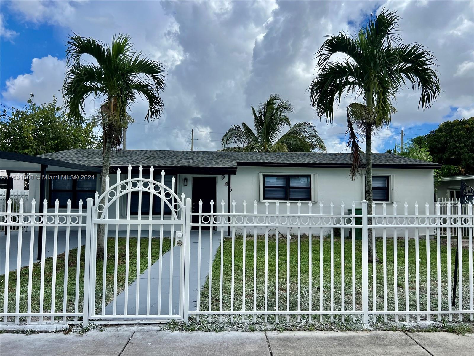 945 Curtiss Drive Opa-Locka, FL 33054 - Photo 2 of 18 a front view of a house with a garden