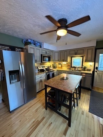 212 Arnold Road Sturbridge, MA 01518 - Photo 5 of 21 a kitchen with stainless steel appliances a table chairs refrigerator and microwave