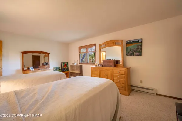 a bedroom with a bed and dresser with mirror