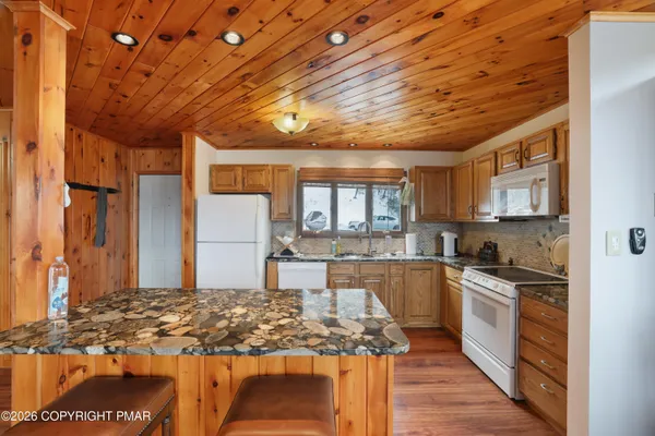 a kitchen with granite countertop a sink a stove and cabinets