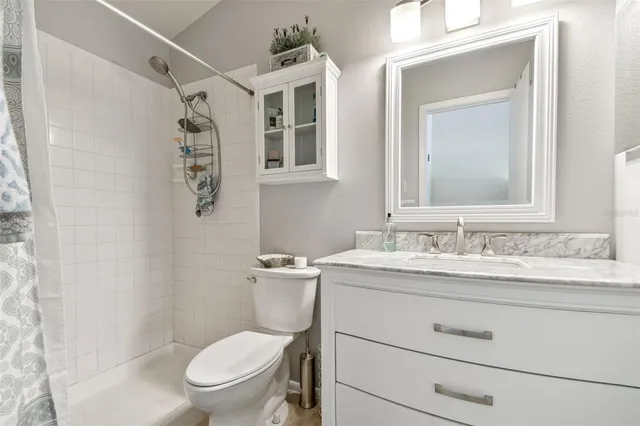 a bathroom with a toilet sink vanity and mirror