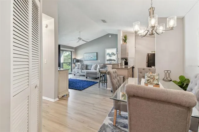a living room with furniture a chandelier and a dining room