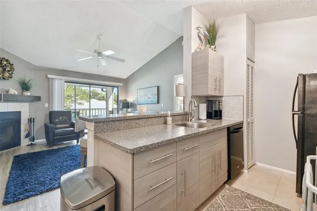 a kitchen with stainless steel appliances granite countertop a kitchen island a stove a sink a dining table and chairs