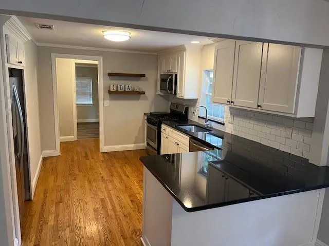 a kitchen with kitchen island granite countertop a sink a stove and refrigerator