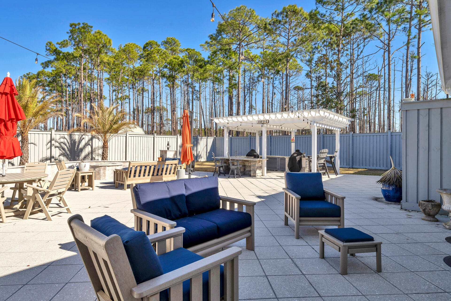 90 Delbert Lane Santa Rosa Beach, FL 32459 - Photo 38 of 47 a view of a patio with couches and a table and chairs with wooden fence