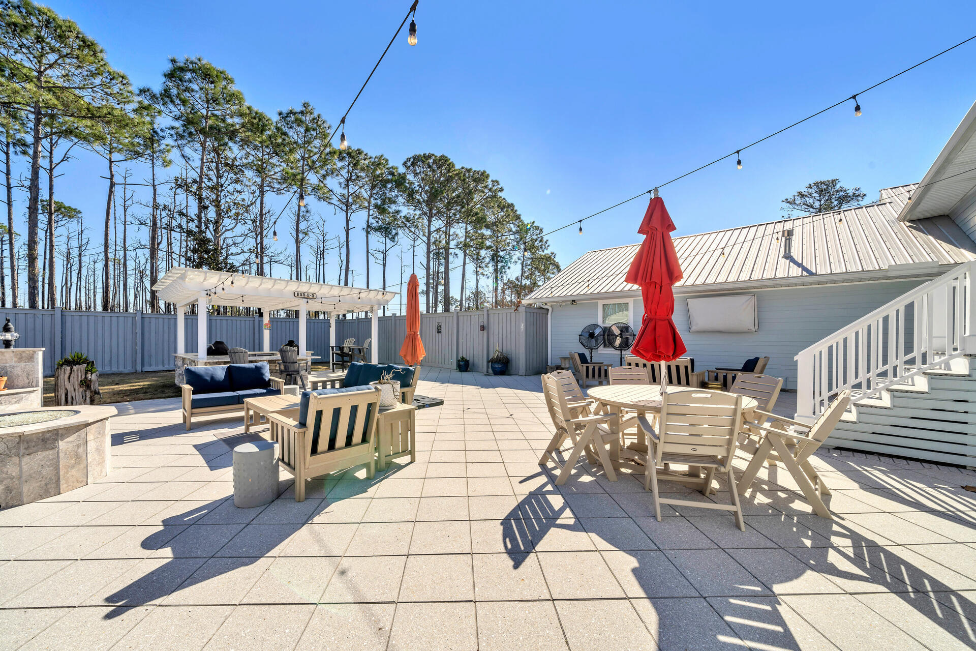 90 Delbert Lane Santa Rosa Beach, FL 32459 - Photo 44 of 47 a view of a patio with dining table and chairs with wooden floor and fence
