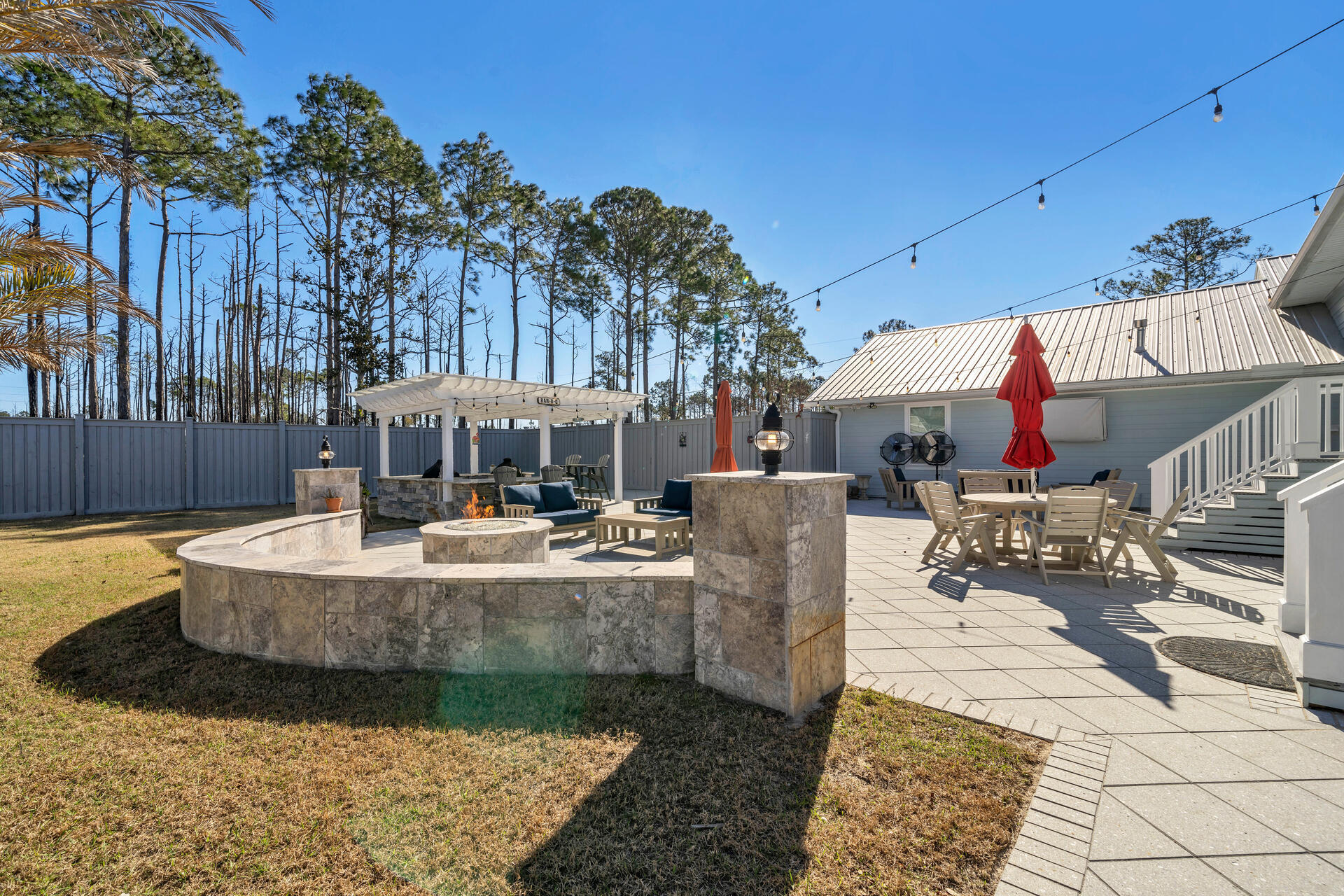 90 Delbert Lane Santa Rosa Beach, FL 32459 - Photo 46 of 47 a view of a patio with table and chairs potted plants