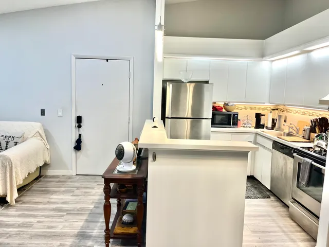 a kitchen with white cabinets and appliances