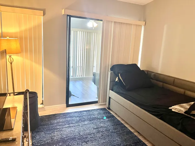 a view of a hallway with wooden floor and glass door