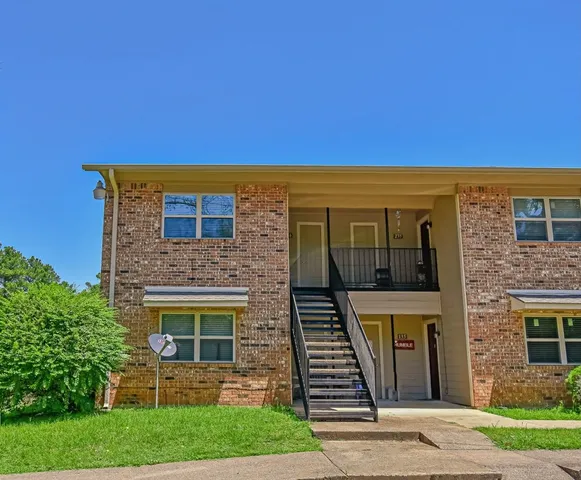 a view of a brick house with a yard