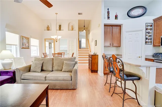 a living room with furniture kitchen view and a wooden floor