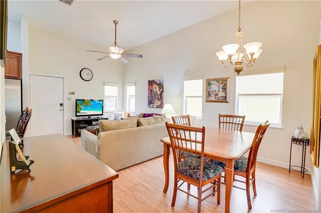 a view of a dining room with furniture a chandelier and wooden floor