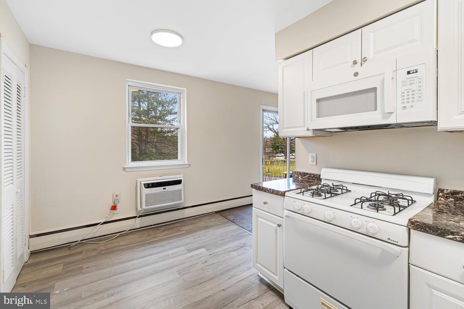 1600 Church Road, Unit D205 Wyncote, PA 19095 - Photo 11 of 21 a kitchen with granite countertop cabinets stainless steel appliances and wooden floor