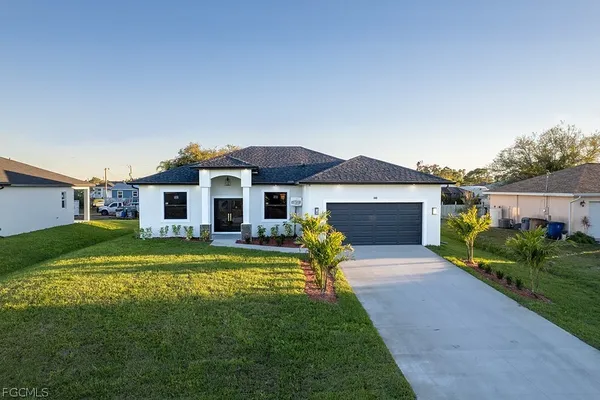 a front view of a house with a garden and yard