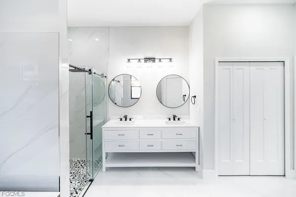 a bathroom with a double vanity sink mirror and shower