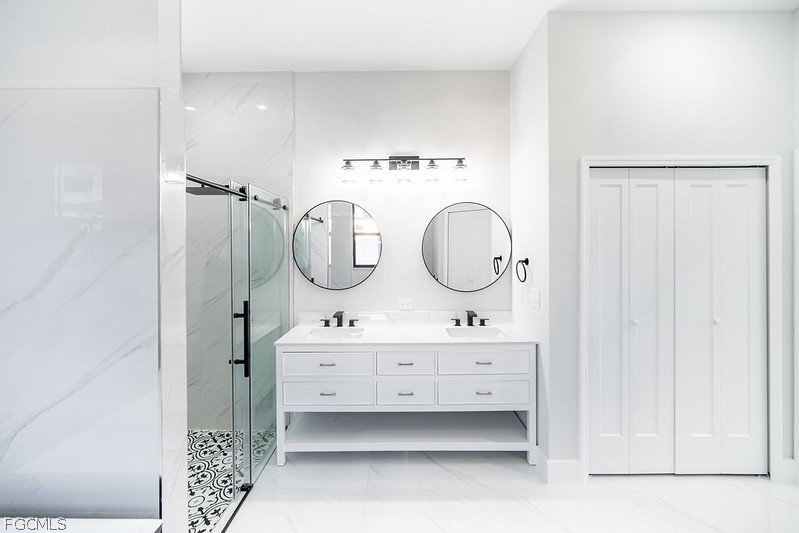 3313 36th Street Southwest Lehigh Acres, FL 33976 - Photo 16 of 27 a bathroom with a double vanity sink mirror and shower