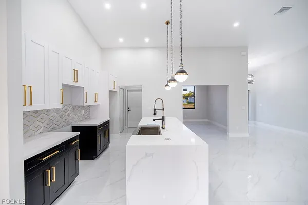 a kitchen with stainless steel appliances kitchen island granite countertop a stove a sink and a refrigerator