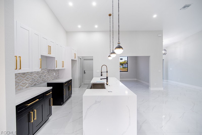 3313 36th Street Southwest Lehigh Acres, FL 33976 - Photo 6 of 27 a kitchen with stainless steel appliances kitchen island granite countertop a stove a sink and a refrigerator