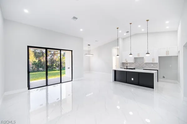 a large white kitchen with a large window and cabinets