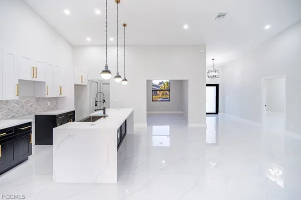 a living room with kitchen island furniture and a chandelier