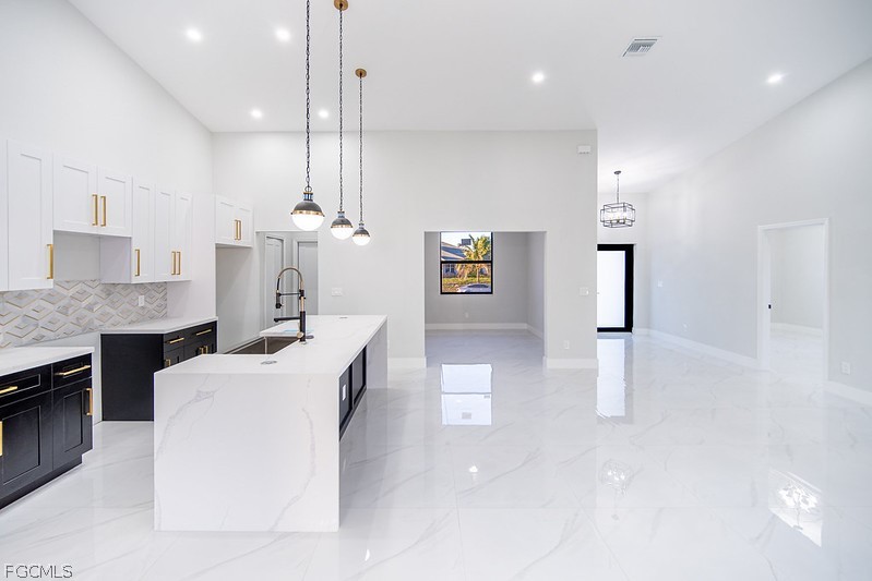 3313 36th Street Southwest Lehigh Acres, FL 33976 - Photo 8 of 27 a living room with kitchen island furniture and a chandelier