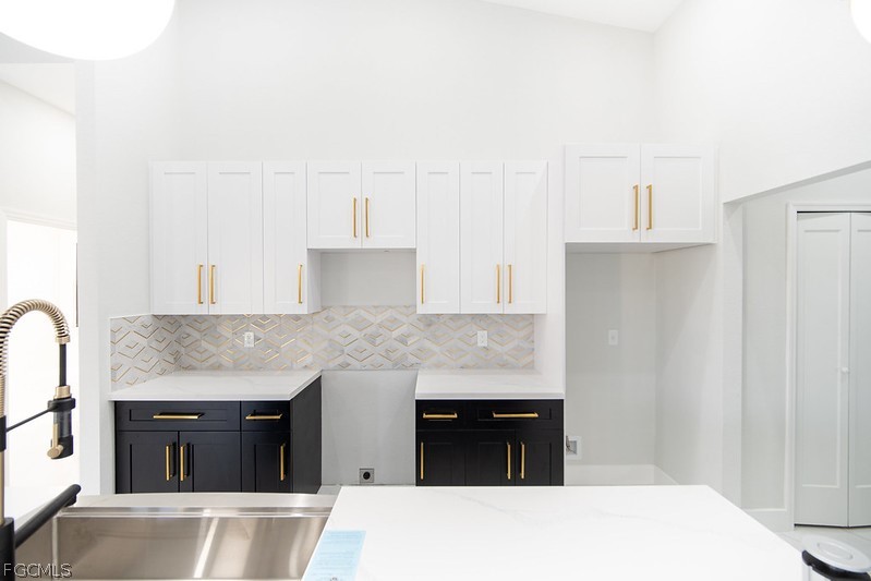 3313 36th Street Southwest Lehigh Acres, FL 33976 - Photo 10 of 27 a kitchen with stainless steel appliances kitchen island granite countertop a stove a sink and a refrigerator