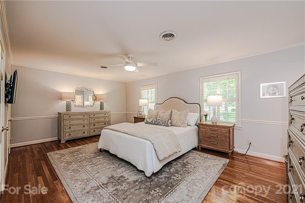 2831 Wickersham Road Charlotte, NC 28211 - Photo 30 of 47 a bedroom with a large bed and a chandelier