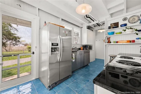 a dining room with furniture a potted plant and a large window