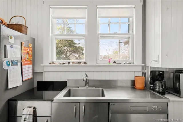 a dining room with furniture a potted plant and a large window