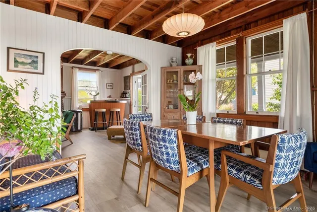 a dining room with furniture window and wooden floor