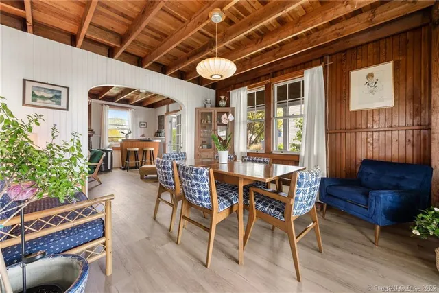 a dining room with furniture a chandelier and wooden floor