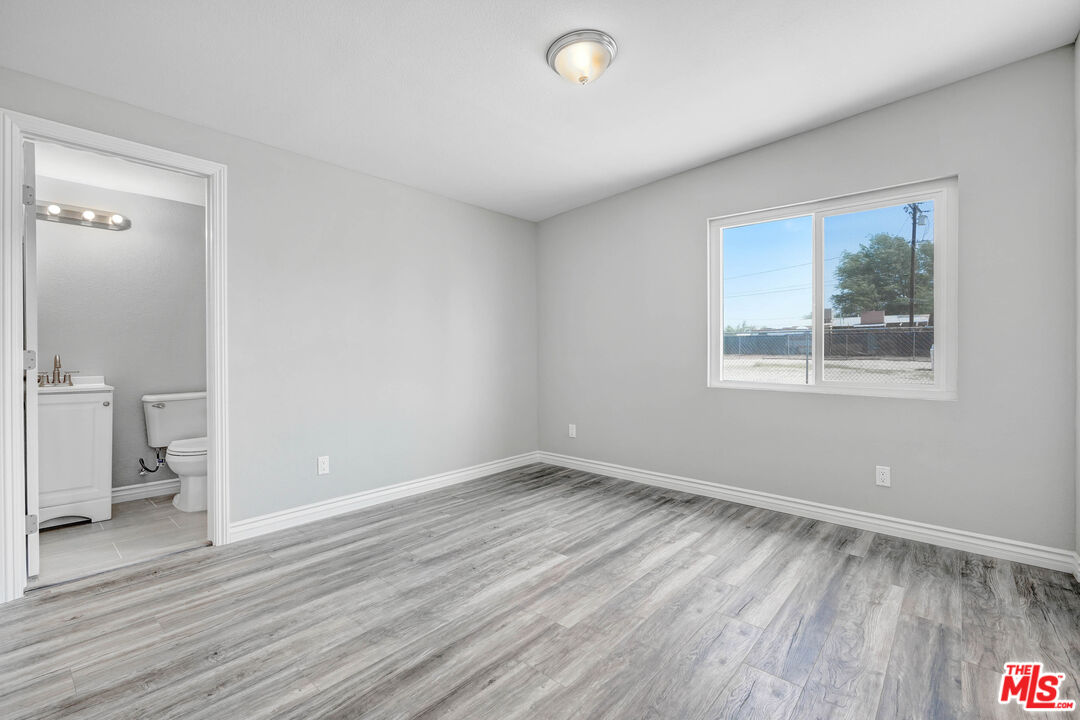 35233 Birch Road Barstow, CA 92311 - Photo 11 of 13 a view of an empty room with wooden floor and a window