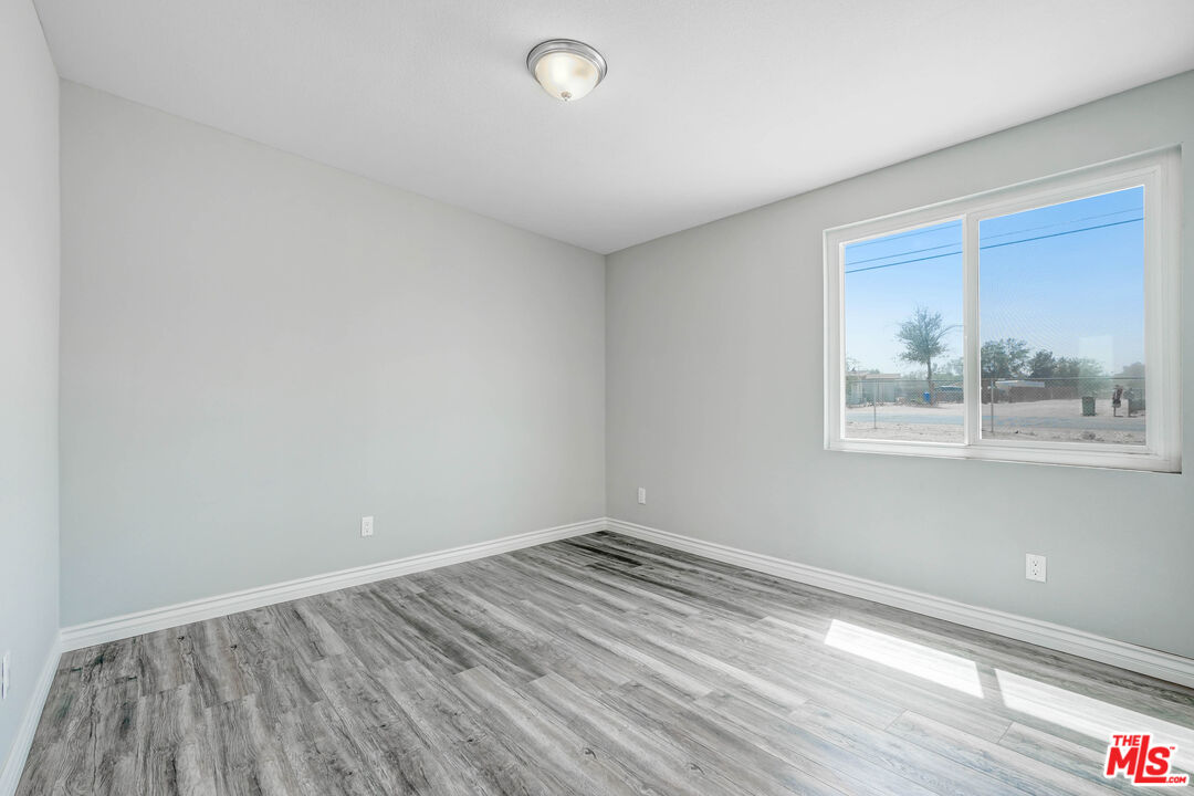 35233 Birch Road Barstow, CA 92311 - Photo 9 of 13 wooden floor in an empty room with a window