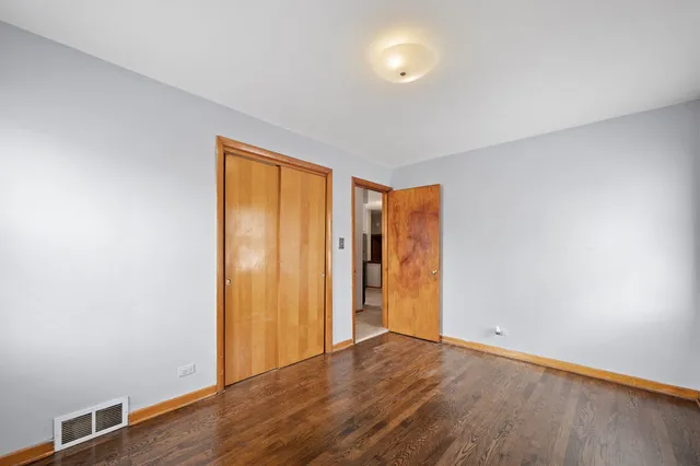 an empty room with wooden floor and closet
