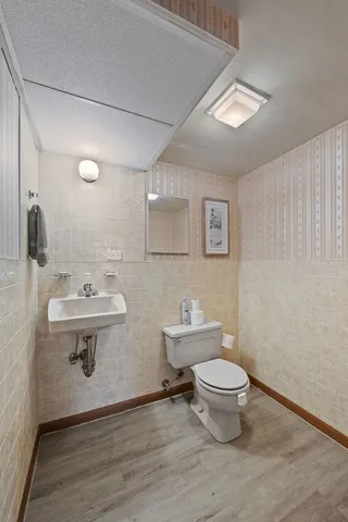 a bathroom with a sink a toilet a mirror and shower