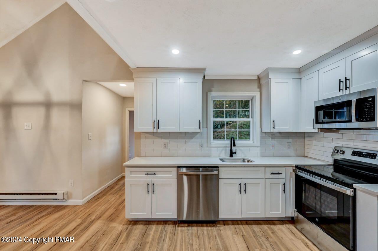2228 Southport Drive Bushkill, PA 18324 - Photo 12 of 56 a kitchen with stainless steel appliances granite countertop a stove a sink and a microwave
