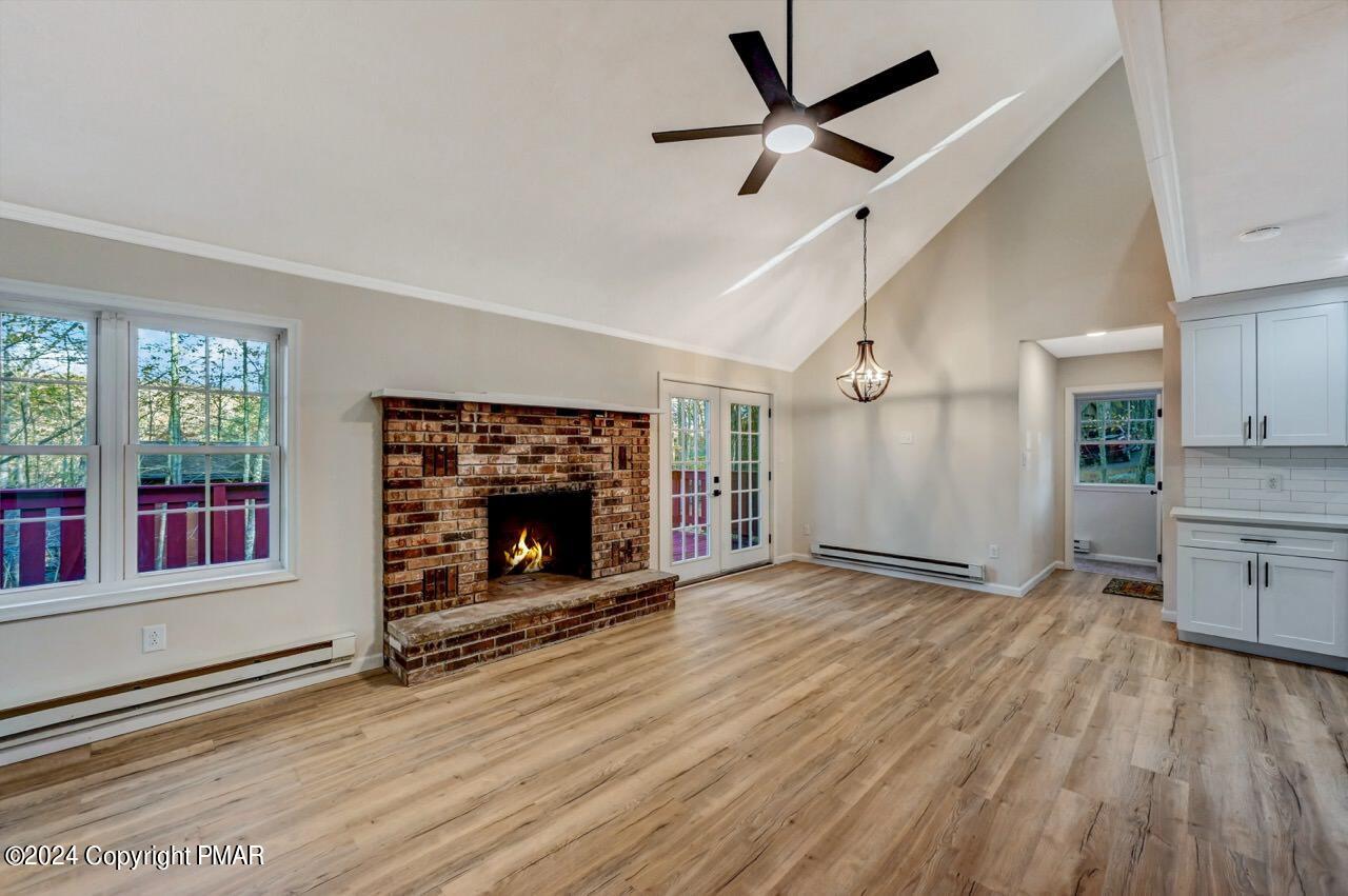 2228 Southport Drive Bushkill, PA 18324 - Photo 2 of 56 an empty room with windows fireplace and wooden floor